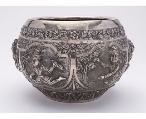 A Burmese silver rice bowl, late 19th or early 20th century, of globular form, chased in relief panels of traditional figures