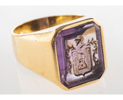 An amethyst intaglio ring with family crest, the intaglio of rectangular form with a carved family crest, marked 18K, size U1