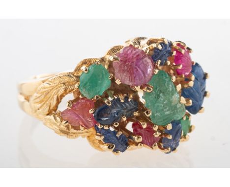 An emerald, sapphire and ruby 'tutti frutti' cocktail ring, with foliate openwork carved shoulders and claw set with an array