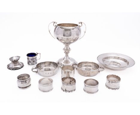 A mixed group of silver including; a North Hants two handled trophy cup, six various napkin rings, a Elizabeth II silver Arma