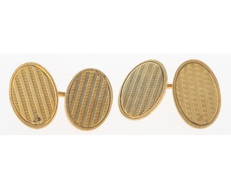 A pair of oval cufflinks, with lined engine turned engraving to both faces, bar link, bar indistinct mark 14K, 10.8grams.