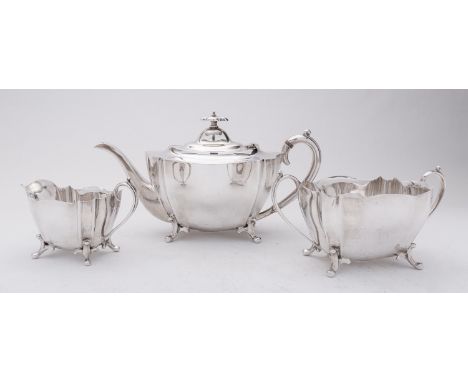 An Edward VII three piece silver tea service by George Wish, Sheffield 1906, of shaped oval form, the domed hinge finial with