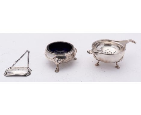 A George V silver tea strainer and stand by Adie Brothers Ltd, Birmingham 1926, set on a cauldron base with three shell cappe