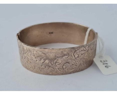 A wide silver chased bangle, 51 g.