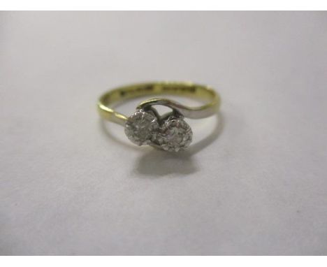 An 18ct gold and platinum diamond, two stone cross-over ring 