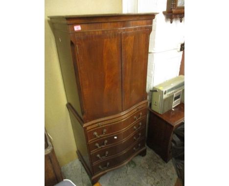 A modern mahogany serpentine fronted drinks cabinet with three doors, a drawer and a slide, on bracket feet 