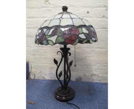 A modern Tiffany style lamp with a floral shade on a bronzed coloured base with leaves, 22" h 