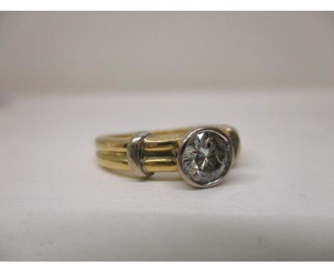 A gold coloured metal solitaire diamond ring in a white gold coloured metal rub-over setting, stamped 750, approx .75ct A/F, 