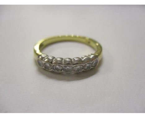 A seven stone diamond ring set in a yellow metal mount 