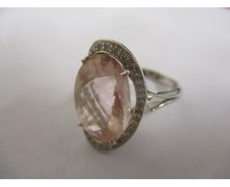 An 18ct white gold ring set with a pink stone and moissanite chips 