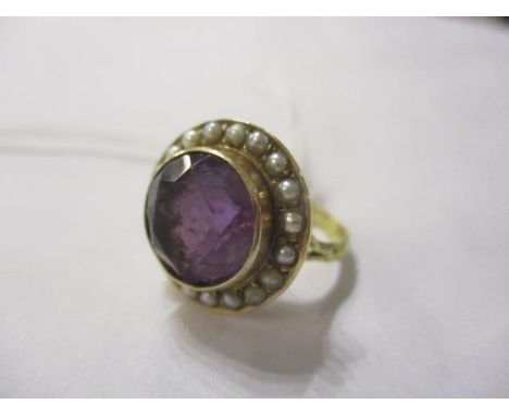An amethyst and seed pearl ring set in a yellow metal mount 
