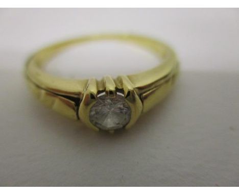 An 18ct gold solitaire diamond ring in a rub-over setting, approx 0.5ct 