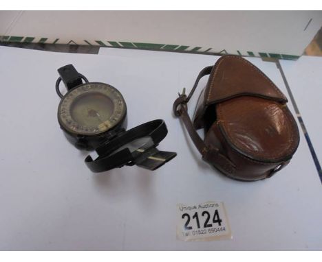 A leather cased military compass.