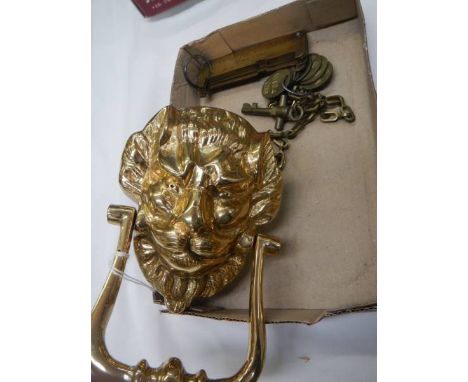 A brass lion head door knocker and other brassware.