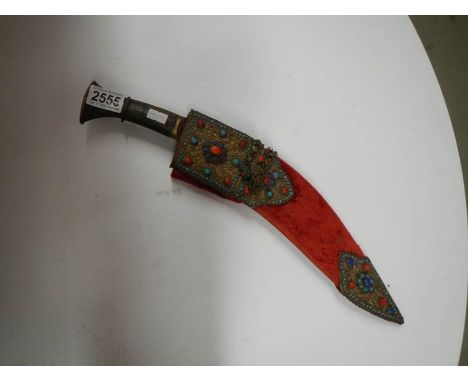 A vintage kukri with stone encrusted gilded red velvet scabbard.