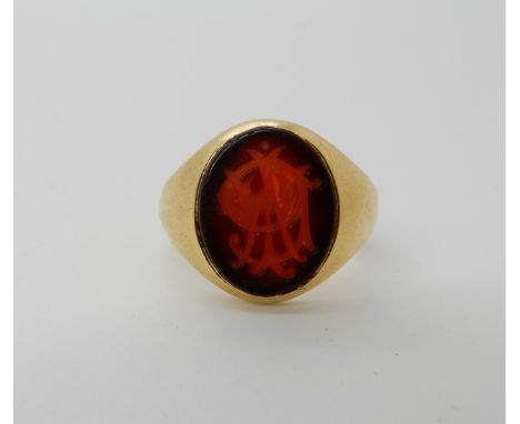 A bright yellow metal signet ring set with a intaglio monogrammed agate, size K, weight 6.2gms Condition Report: Available up