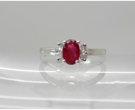 An 18ct white gold ruby and diamond ring, dimensions of the ruby 5.9mm x 4mm x 3.1mm, with marquis cut diamond set to the sho