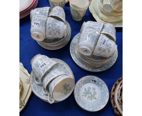 A Wedgwood bone china tea set decorated with flowers comprising eleven plates and cups, twelve saucers, cake plate, two jam d