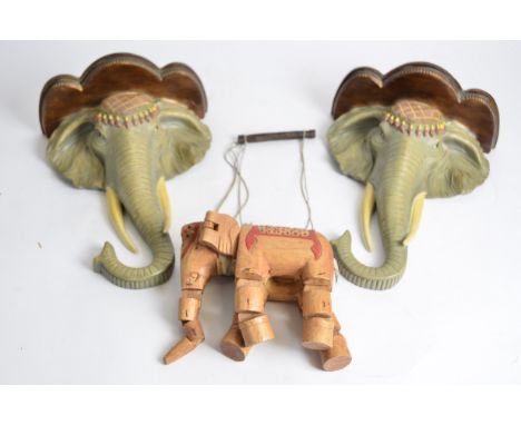 A pair of elephant wall mounts,  36cm x 27cm x 13.5cm, together with an elephant puppet (3) 
