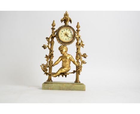 A 20th Century mantle clock with gilt putto and foliage surround,  raised on an onyx stand, the dial with Arabic numerals and
