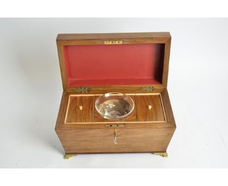A mid 19th Century tea caddy of sarcophagus form,  raised on four lions paw feet, with lock and key, glass liner and a Georgi
