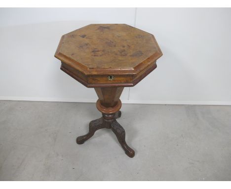 A Victorian octagonal walnut sewing table, with moulded rising top, raised on a carved tripod base, height 72cm