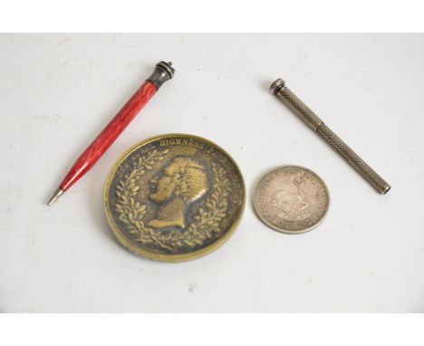 An early 20th Century silver pencil together with a another Bakelite example,  a Prince Albert Great Exhibition brass paperwe