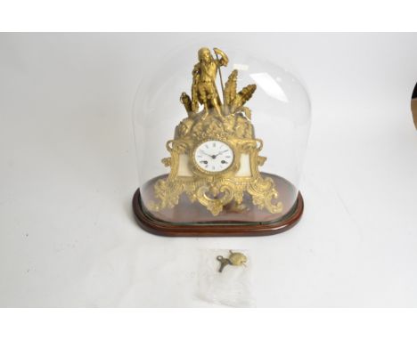 A French mantle clock under glass dome,  with gilt surround, raised on two straight and two scrolling feet, surmounted by a f