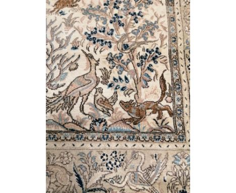 A woollen carpet,  with central section of interspersed woodland animals, with a rectangular surround of repeating birds and 