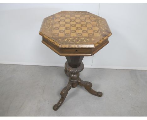 A Victorian octagonal walnut sewing table, rising top with parquetry and marquetry chequered board, raised on a carved tripod