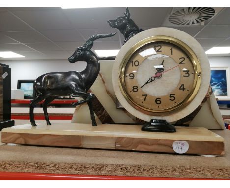 A French Art Deco mantel clock, in cream and brown marble, circular brass face with Arabic numerals and a modern electric mov