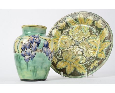 Della Robbia Pottery (Birkenhead 1894-1906), an ovoid vase with sgraffito decoration of grapes amidst vines, on a glazed gree