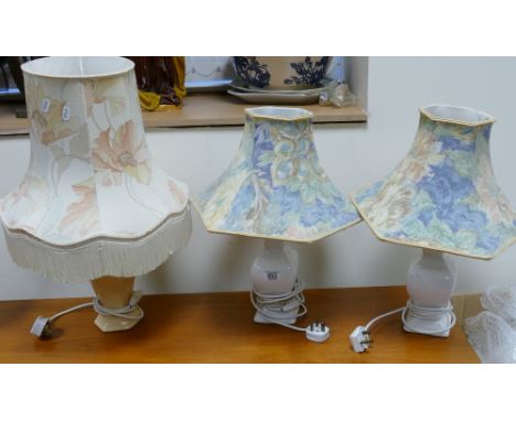 A pair of white ceramic lamp bases with shades: together with a larger similar lamp base and shade