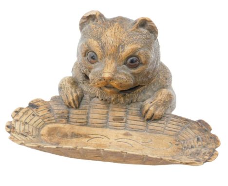 A late 19th/early 20thC Black Forest inkwell, modelled in the form of a young bear with glass eyes, with hinged lid, enclosin