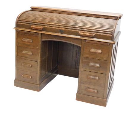 A Lebus oak roll top desk, with an arrangement of nine drawers on a plinth, 121cm wide.