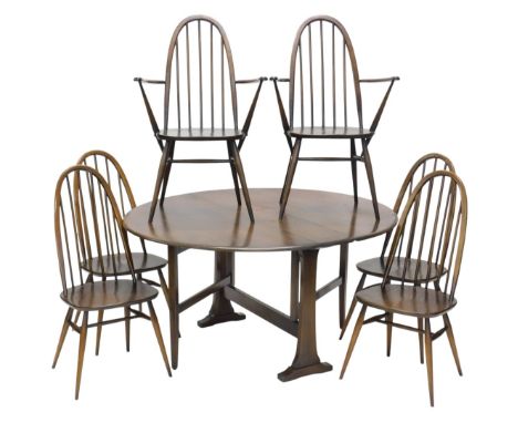 An Ercol elm oval drop leaf table, on shaped end supports, 128cm wide, and six spindle back chairs, each with a solid seat an