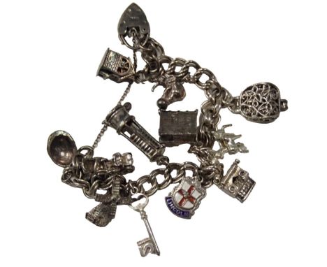 A charm bracelet, on double curb link bracelet with safety chain and heart shaped padlock, various charms including miner's l