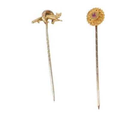 Two stick pins, comprising a horse's hoof and fox topped stick pin, unmarked, and a cluster set with central ruby and yellow 