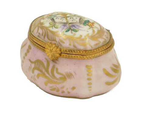 A French porcelain trinket box, on a pink ground decorated with trumpet and books, marked Made in France, 6cm high.