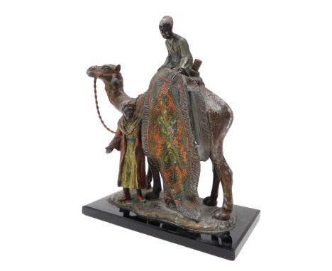 An early 20thC Cold painted spelter table lighter, modelled in the form of a camel beside two rug salesmen, on rectangular ba