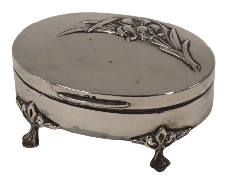 A George V silver trinket box, the oval top with lilies, on four claw feet, with a green baize lined interior, Birmingham 192