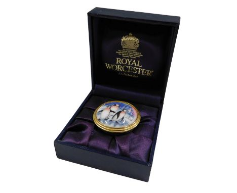 A Royal Worcester enamel pill box, decorated with three penguins, 3.5cm diameter, in fitted case.