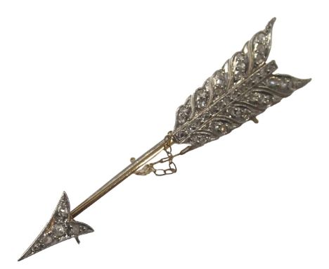 An arrow brooch, on a yellow and white gold setting, set with tiny diamonds, on a feathered bow, yellow metal unmarked, with 