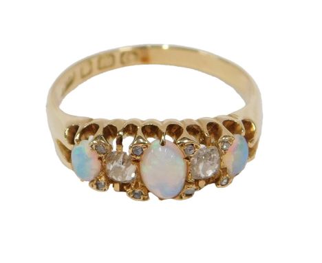 An 18ct gold late 19th/early 20thC opal and diamond half hoop dress ring, set with three cabochon cut opals and ten old mine 