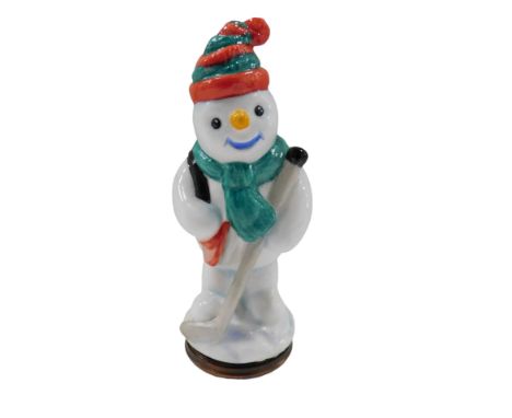 A Halcyon Days enamel snowman pill box, depicting snowman with hockey stick, 9cm high, boxed.