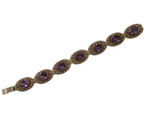 A 9ct gold and amethyst bracelet, with seven oval panel design, each centred with oval amethyst, in a rub over setting, pierc