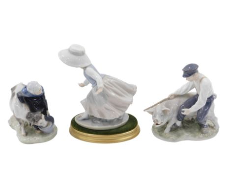 A pair of Royal Copenhagen porcelain figurines, of a farmer with pig, and a farmer's wife with cow, each on a shaped base, bl
