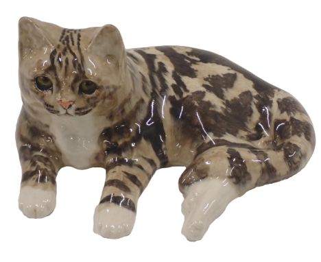 A Winstanley studio pottery recumbent tabby cat, signed to underside, 34cm wide.