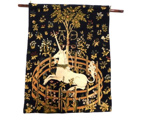 A 20thC Aubusson style hanging tapestry, with unicorn in brass ring, decorated with palm trees, on a wooden rod, with brass m