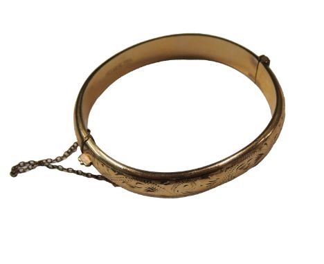 A 20thC hinged bangle, of half floral design, with safety chain stamped 9ct gold metal core, 7cm diameter.